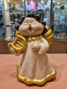 Delightful ceramic angel figurine holding a lyre, perfect for festive holiday decor.
